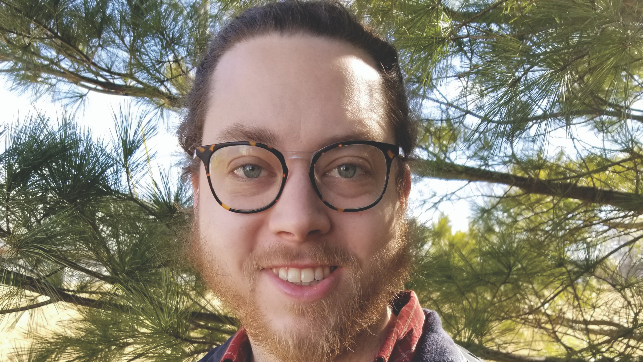 Jeff Hill smiling in front of a tree in nature.