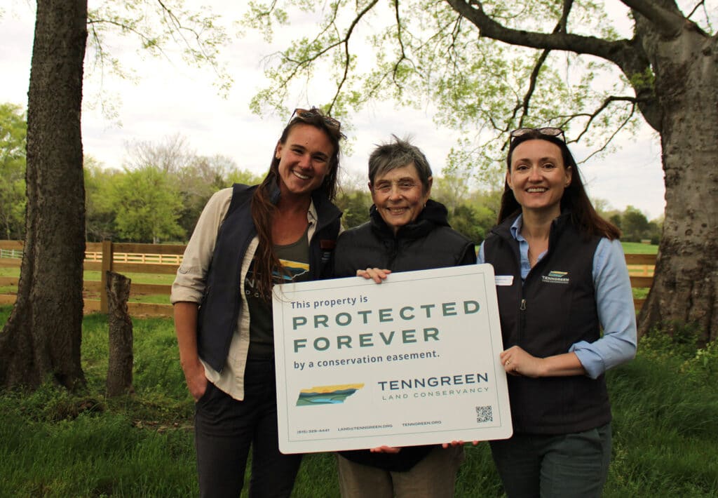 Group holding sign that reads "Protected Forever"